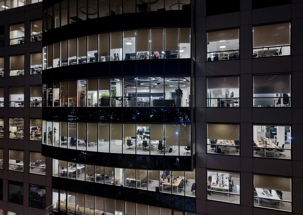 Fragment of the glass facade of a modern corporate building at night